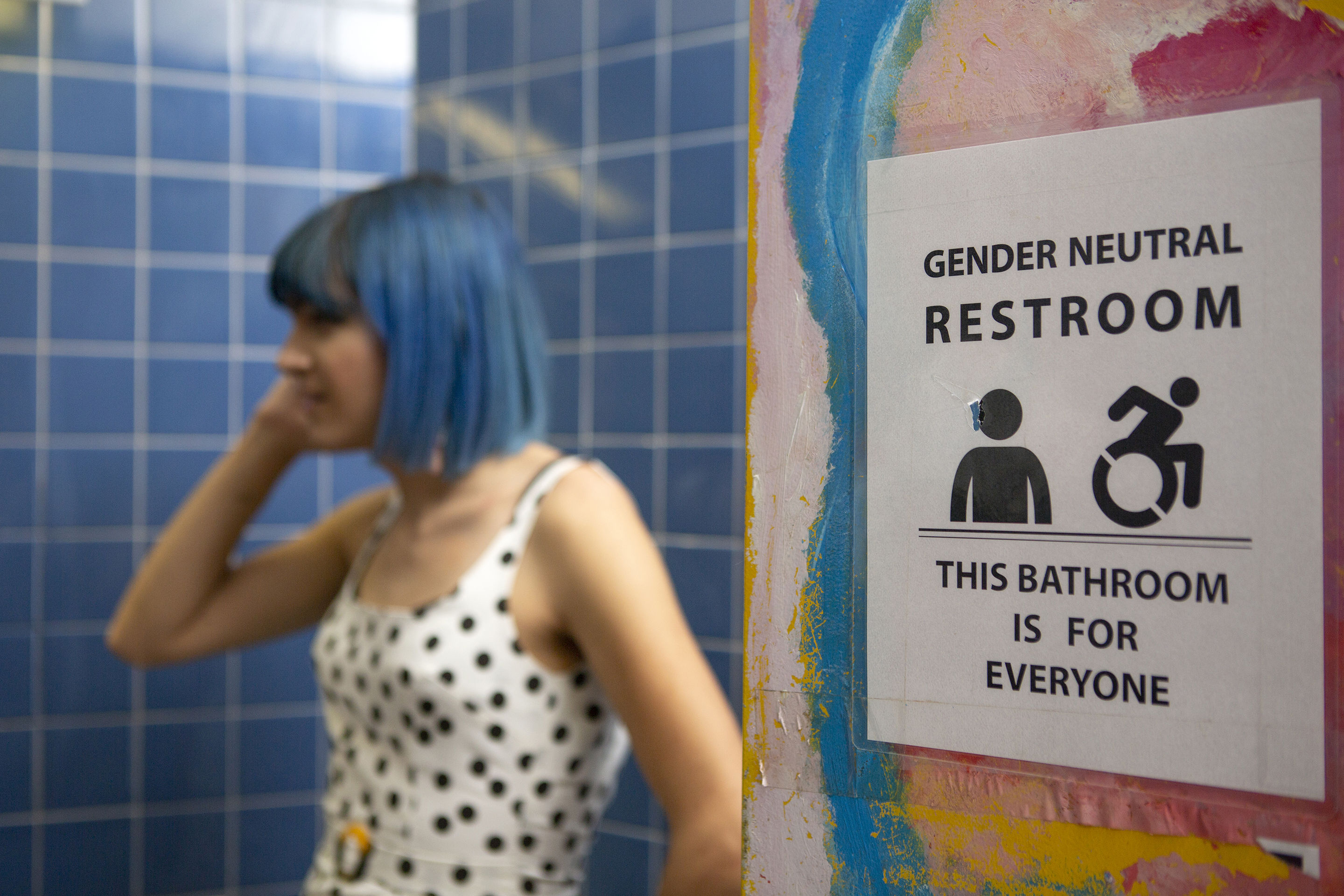 A non-binary femme in a gender neutral bathroom